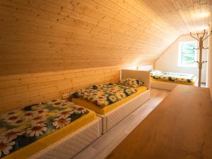 3 camas en una habitación con paredes de madera en Resort U sýrárny en Sobotín