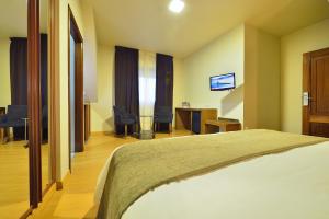 מיטה או מיטות בחדר ב-Hotel Puente de La Toja