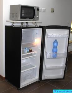 a refrigerator with a bottle of water and a microwave at Happyhouse in Turin