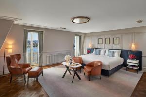 a hotel room with a bed and a table and chairs at Mandarin Oriental Palace, Luzern in Luzern