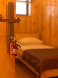 a room with a bed with a sign on a door at WOOD MOTEL in Mingachevir