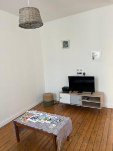 - un salon avec une table basse et une télévision dans l'établissement Appartement à 2 minutes de la plage 5 places, à Berck-sur-Mer