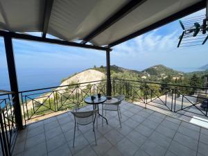 balcone con tavolo, sedie e vista di La Casa D' Irene a Ayios Nikitas