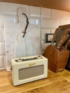 um rádio e uma guitarra num piso de madeira em Northbrook Cottage, Farnham, up to 8 adults em Farnham