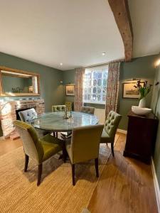 a dining room with a glass table and chairs at Northbrook Cottage, Farnham, up to 8 adults in Farnham