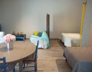 una camera con tavolo, letto e divano di Gite Le Petit Luberon LISIANTHUS a Cabrières-dʼAvignon