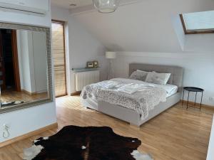a white bedroom with a bed and a mirror at Dom nad Zalewem Zegrzyńskim in Nieporęt