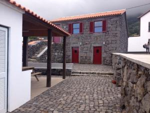 a brick building with a stone wall at Pico da Saudade in Prainha de Baixo