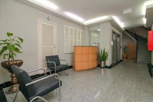 une salle d'attente avec deux chaises et un escalier dans l'établissement Ap Embarcadero, à Porto Alegre
