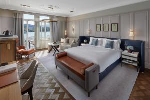a bedroom with a large bed and a living room at Mandarin Oriental Palace, Luzern in Luzern