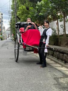 een man in een rode koets met een vrouw bij ワイズパーク向島 in Tokyo