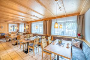アインリングにあるHotel Schaiderの木製の天井、テーブルと椅子のあるレストラン