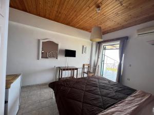 1 dormitorio con cama, mesa y ventana en La Casa D' Irene en Ayios Nikitas