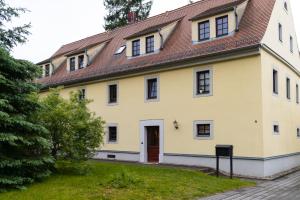 a large yellow house with a brown roof at Liebesgewölbe in Pirna