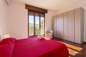 una camera con letto rosso e finestra di Villa Stella Nord a Marsala