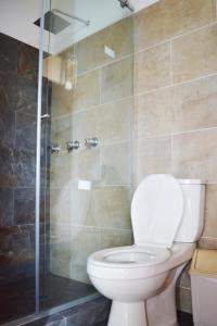a bathroom with a toilet and a glass shower at Hotel Mirador Las Palmas in Armenia