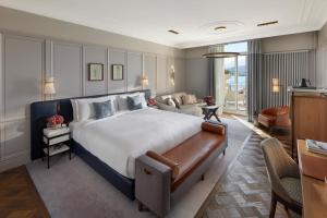 a bedroom with a large bed and a living room at Mandarin Oriental Palace, Luzern in Luzern