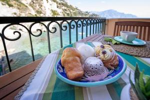 a plate of pastries on a table on a balcony at Borgo di Conca in Conca dei Marini