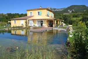 a house sitting on a lake with a house at Chambre d'hôtes Ananda in Sisteron