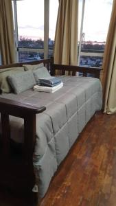 a bed with two books on it in a room with windows at Loft con todo que necesitas solo a 2 cuadras de la costanera!! in Corrientes
