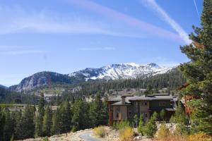 a house on a hill with mountains in the background at Aspen Creek by 101 Great Escapes in Mammoth Lakes