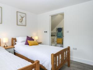1 dormitorio con 2 camas y espejo en Bumblebee Cottage en Wellington