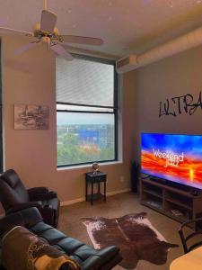 a living room with a couch and a flat screen tv at Downtown CLE Loft, River View, King Bed, Free Parking in Cleveland