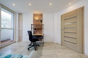 - une chambre avec un bureau et une chaise devant une porte dans l'établissement Crystal Apartment Katowice II, à Katowice
