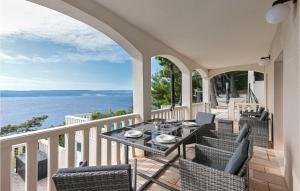 ein Balkon mit Tisch und Stühlen und dem Meer in der Unterkunft Beautiful Apartment In Lokva Rogoznica in Lokva Rogoznica