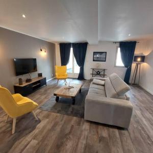 sala de estar con sofá y TV en Gite le 19 - Maison 130m2 - Les Rosiers sur Loire - Chambres climatisées, en Les Rosiers