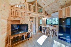 a log cabin with a large television and a living room at Catskills Tiny Home Cabin: Surrounded by Nature! in Franklin