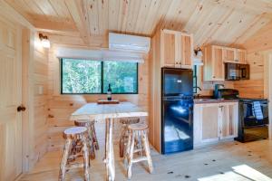 a kitchen with a table and stools in a cabin at Catskills Tiny Home Cabin Surrounded by Nature! in Franklin