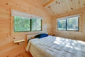 a bedroom with a bed in a log cabin at Catskills Tiny Home Cabin Surrounded by Nature! in Franklin