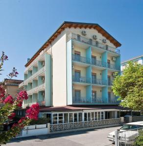 a large white building with balconies on a street at Hotel Saint Tropez SPA & Restaurant in Lido di Savio