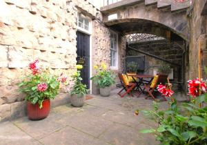 a patio with flowers and a table and chairs at City Centre New Town 2 Bedroom Flat in Edinburgh