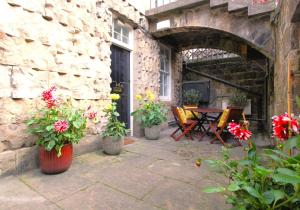 a patio with flowers and a table and chairs at City Centre Contemporary New Town Flat in Edinburgh