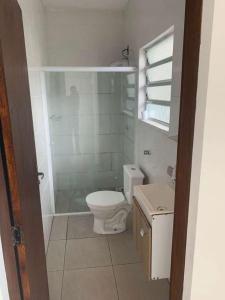 uma casa de banho com um WC, um chuveiro e um lavatório. em Pousada & Hostel Mar dos Ingleses em Florianópolis