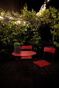 two red chairs and a table with a plant on it at Casa Vacanze Zummer Frei Studio in Pieve di Cadore