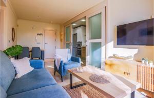 een woonkamer met een blauwe bank en een tafel bij Nice Apartment In Los Alczares With Wifi in Los Alcázares