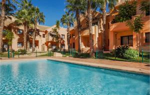 een zwembad voor een gebouw met palmbomen bij Nice Apartment In Los Alczares With Wifi in Los Alcázares