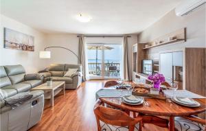 ein Wohnzimmer mit einem Tisch und einem Sofa in der Unterkunft Cozy Apartment In Rtina, Razanac With Kitchen in Miletići