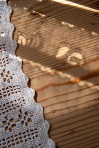 a close up of a crochet blanket on a wooden floor at Casa Vacanze Zummer Frei Studio in Pieve di Cadore