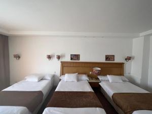 a row of three beds in a room at New eliet pyramids view hotel in Qaryat ash Shamālī