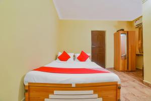 a bedroom with a bed with red pillows on it at OYO Royal Castle Near Baga Beach in Baga