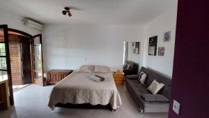 um quarto com uma cama e um sofá em Lindo estúdio perto do Hospital BOS Sorocaba (3) em Sorocaba