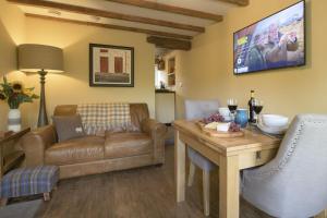 a living room with a couch and a table at Pond Cottage in West Witton