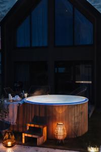 a hot tub on a patio with two lights at Wood House Trzęsacz in Trzęsacz