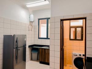 a kitchen with a stainless steel refrigerator and a window at Elles Residence in Dar es Salaam