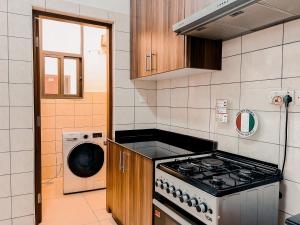 ダル・エス・サラームにあるElles Residenceのキッチン(コンロ、洗濯機付)
