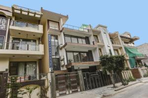 un edificio de apartamentos con balcones y una valla en OYO Townhouse 1071 Hotel Metro Inn Residency Near ISKCON Temple Noida, en Indirapuram